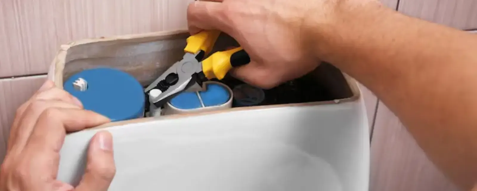 Toilet repair: hands adjusting the fill valve inside an open toilet tank